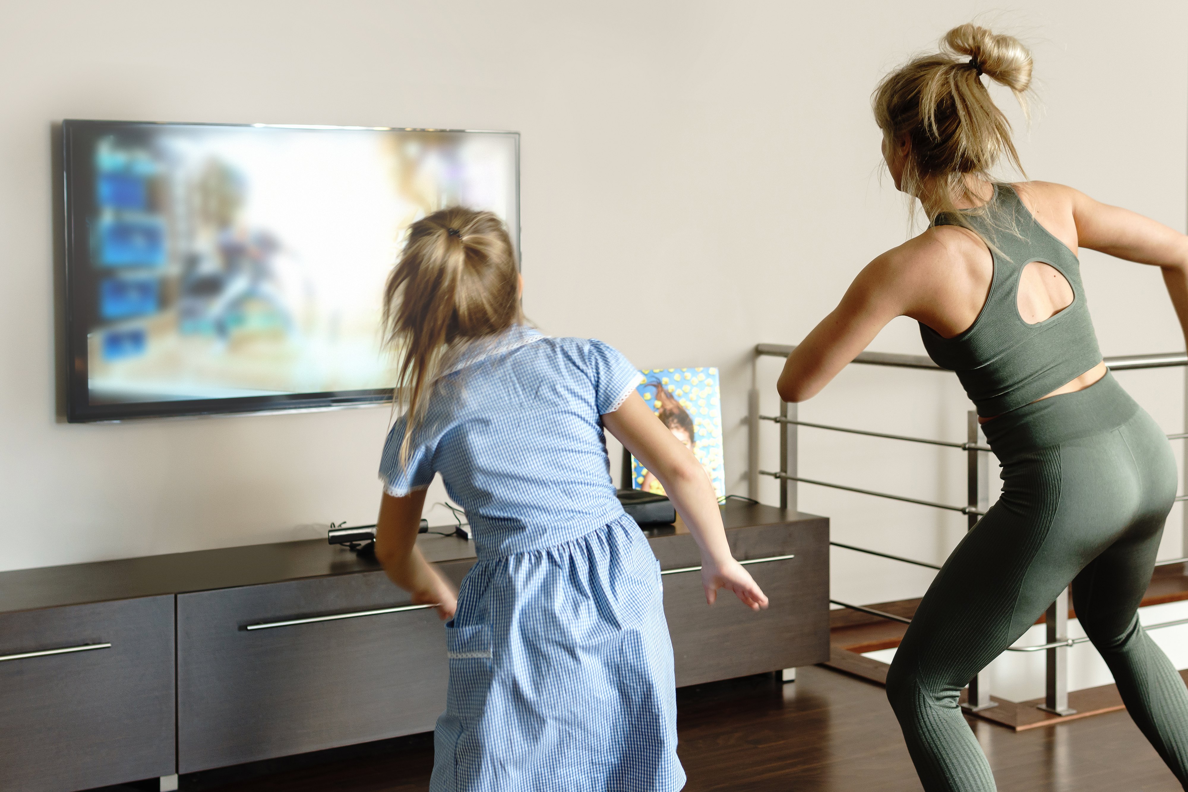 Active family dancing with modern video game console at home