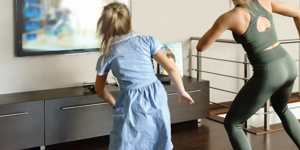 Active family dancing with modern video game console at home