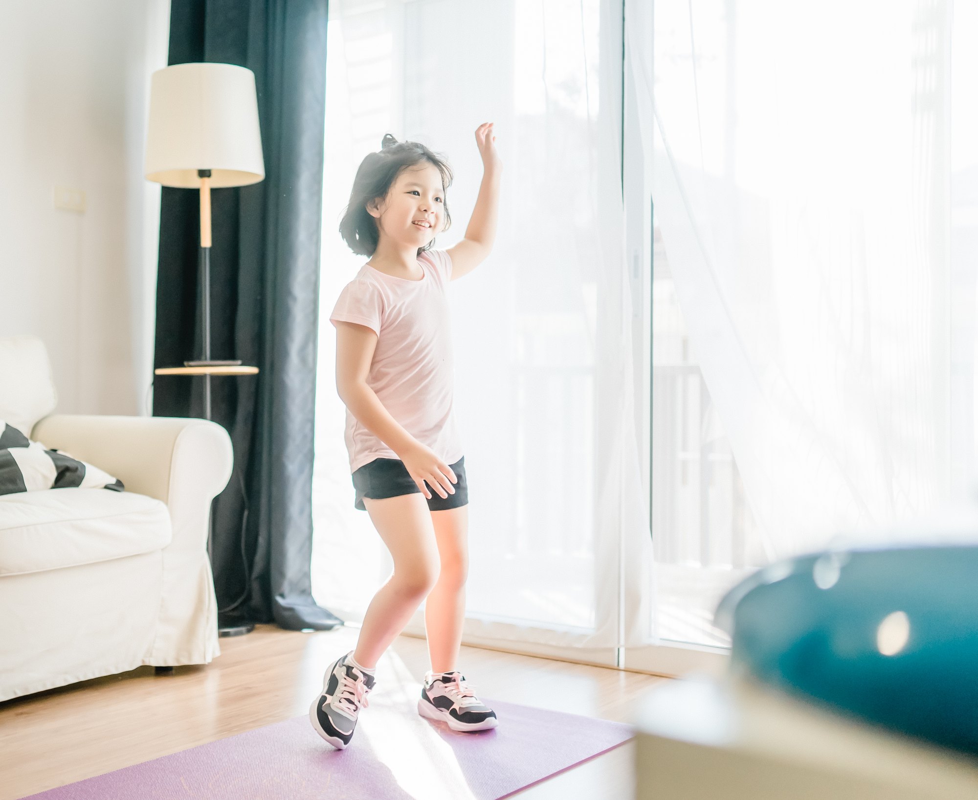 Young girl exercise watching online video on TV and doing fitness exercise dance at home