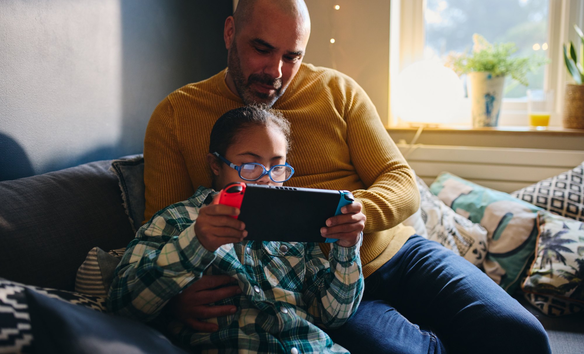 Father watching son play computer game