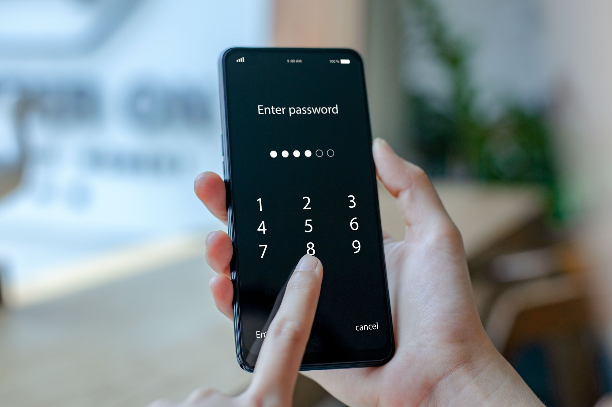 Close up woman hand holding smartphone while entering the passcode