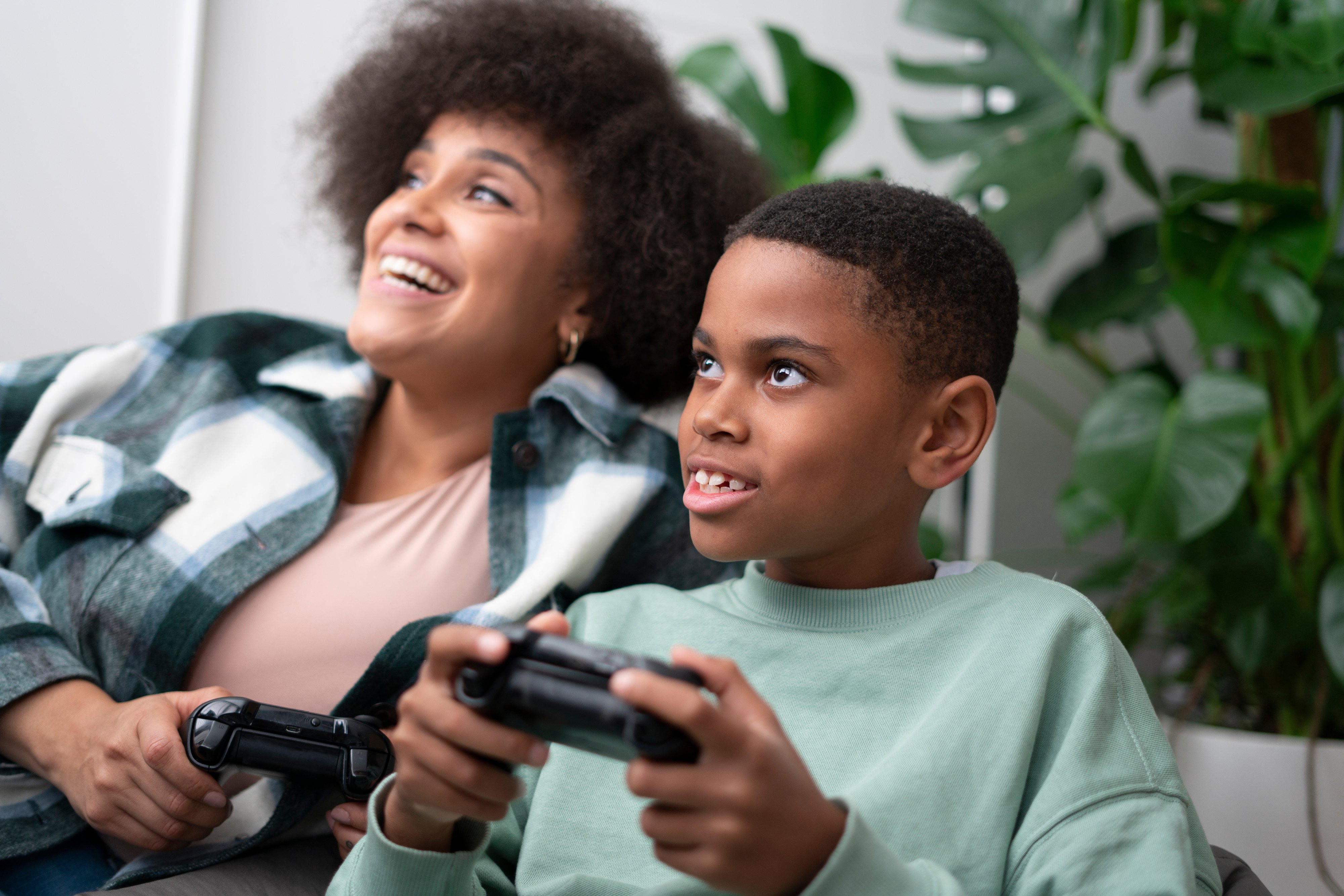 Mother and son playing video games at home