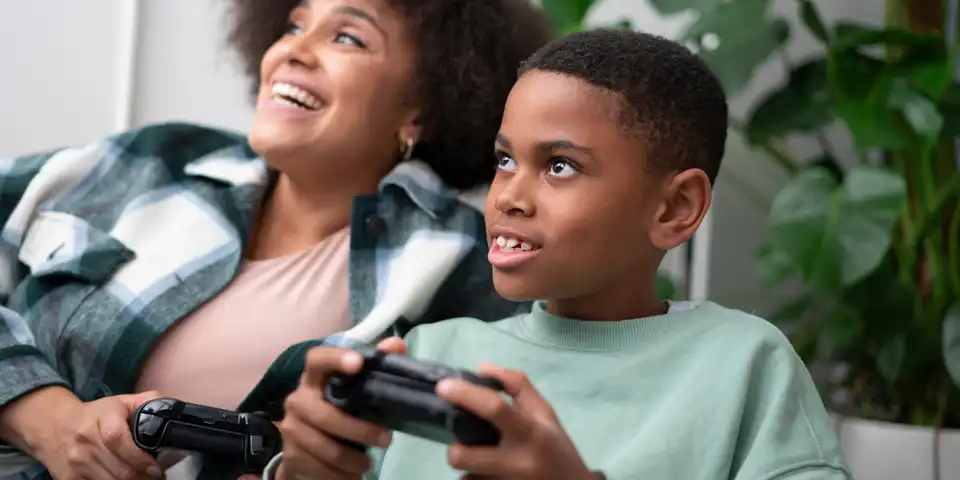 Mother and son playing video games at home