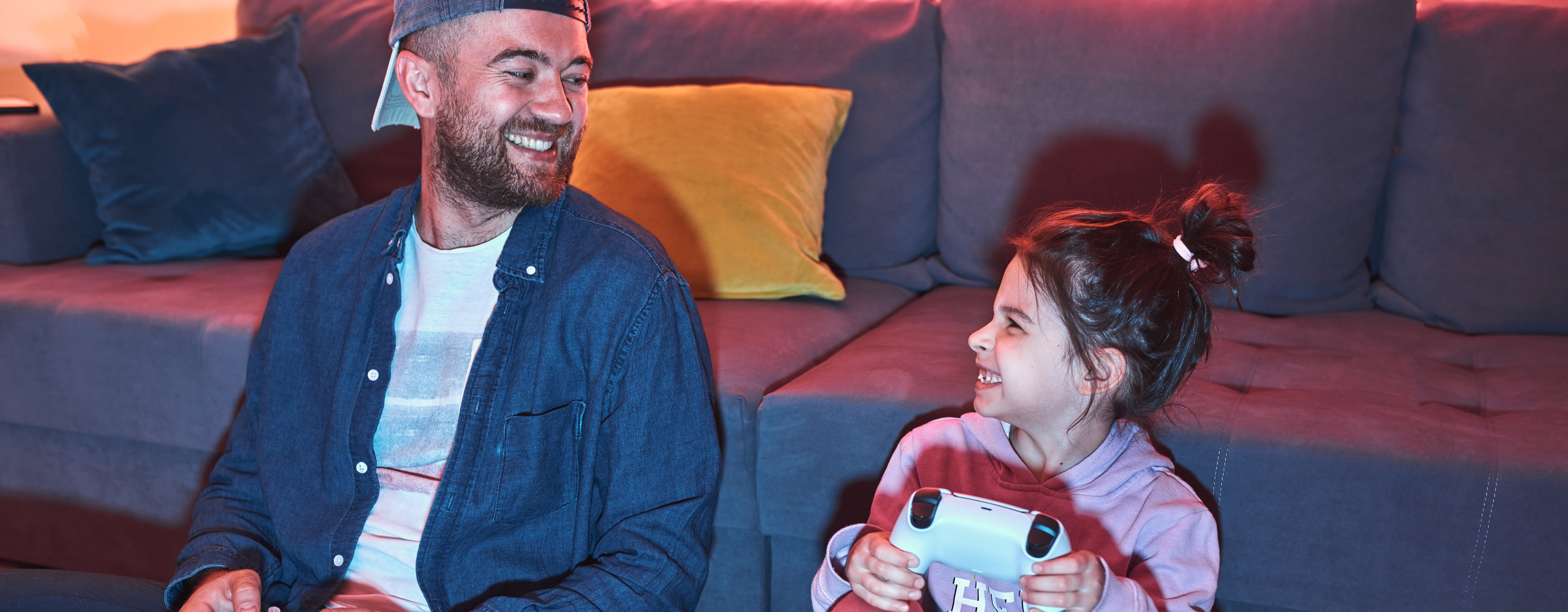 Dad plays computer games with daughter while sitting at home